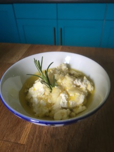 White soft cheese with olive oil and a sprig of rosemary